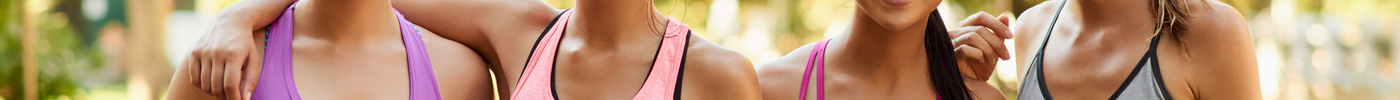 Four women in fitness attire smiling together in a park, showcasing styles that enhance your confidence with fitness attire.