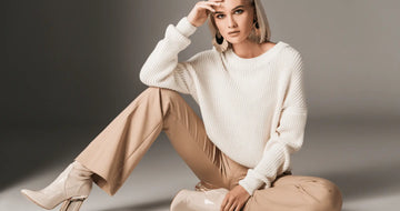 A cozy off-white knitted sweater with a relaxed fit and ribbed cuffs for fashionable ways to style palazzo pants.
