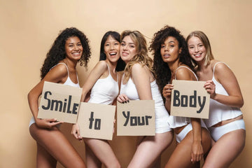 Five women in white underwear hold smile to your body signs promoting royalessencelux body care essentials collection