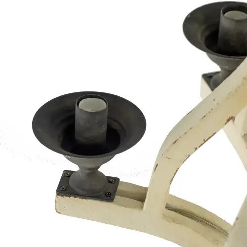 black metal candle holder with distressed white painted frame complementing the 6 light wood chandelier for dining hall entrance