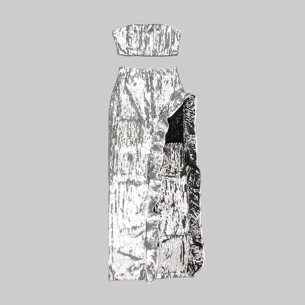 silver metallic sequin skirt set featuring a strapless top and high-waisted skirt with an asymmetrical slit.
