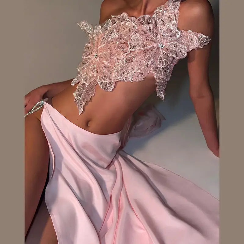 a delicate pink lace crop top with intricate floral appliqués paired with a satin backless sequined split skirt suit