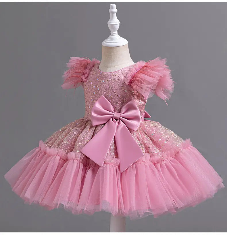pink sequined toddler dress with feathered puff sleeves and a layered tulle skirt accented by a large satin bow at the waist suitable for wedding dress tulle skirt summer occasions.