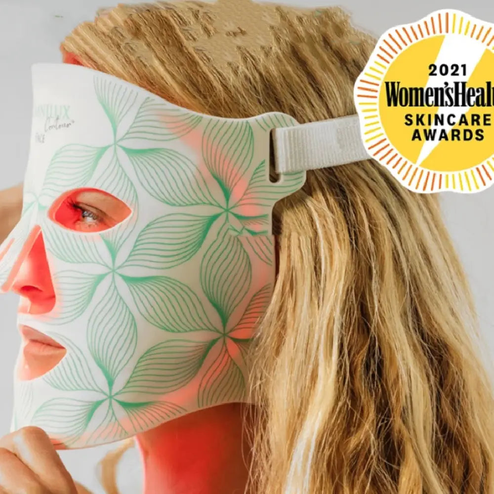 white face mask with green leaf pattern and glowing red light designed as a collagen anti aging beauty instrument for skincare treatment
