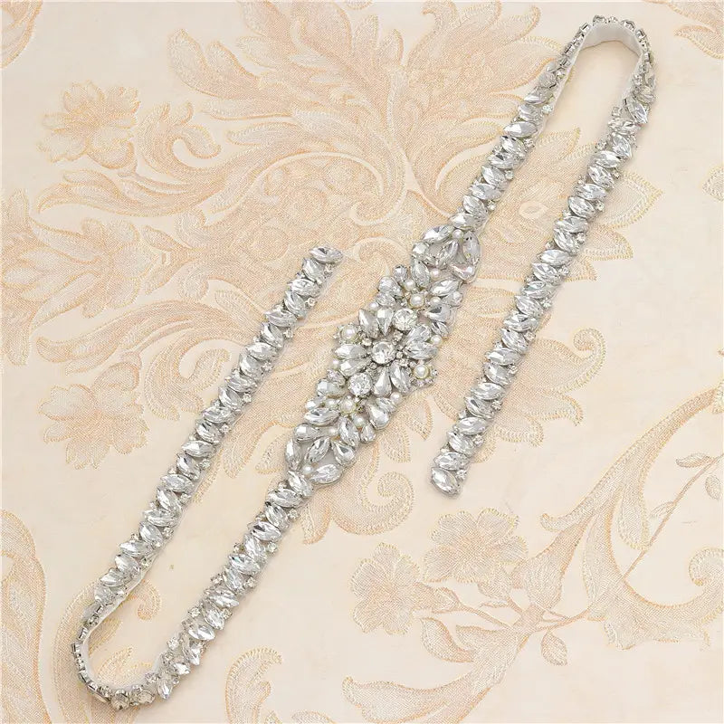 Silver rhinestone applique wedding sash belt with a central floral design and elongated straps for wedding dress waist decoration.