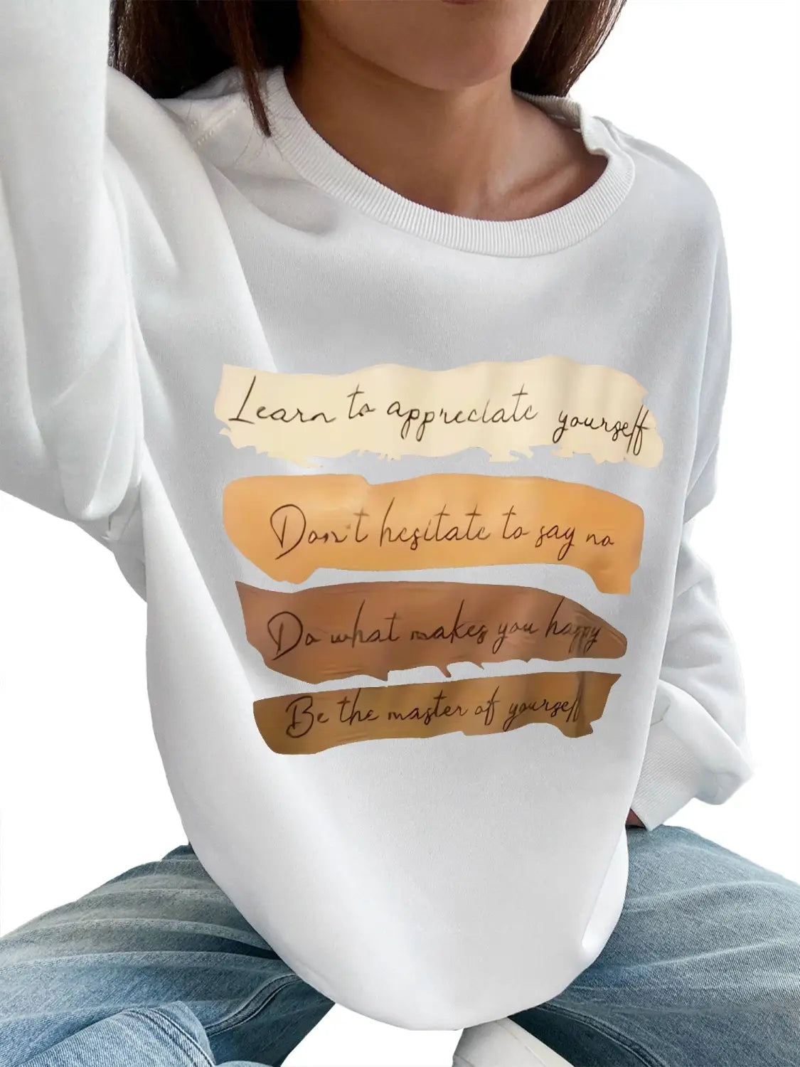 White oversized long sleeve sweatshirt in solid colour featuring motivational phrases printed in brown cursive on layered torn-paper-style orange and beige stripes perfect for daily wear.