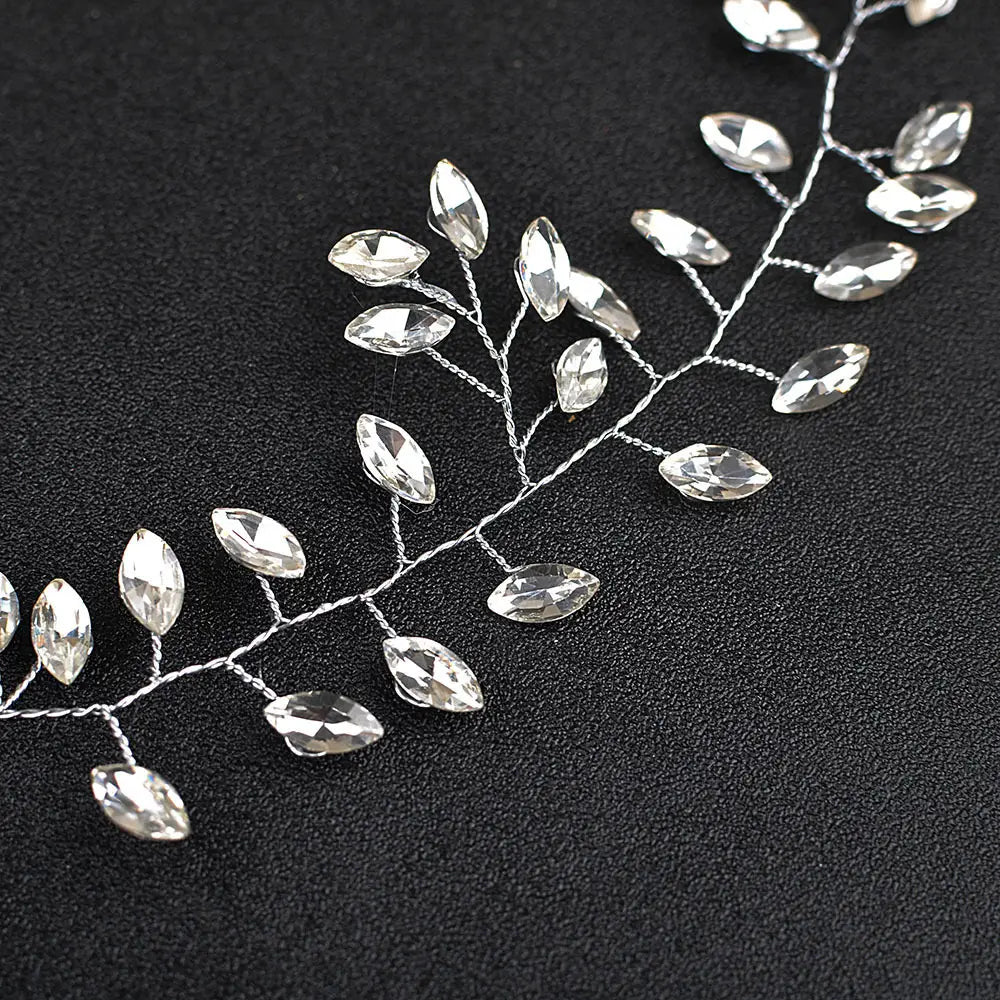 Delicate silver wire hair vine adorned with clear faceted crystal leaves in a horse eye silver flexible chain wedding hair accessory.