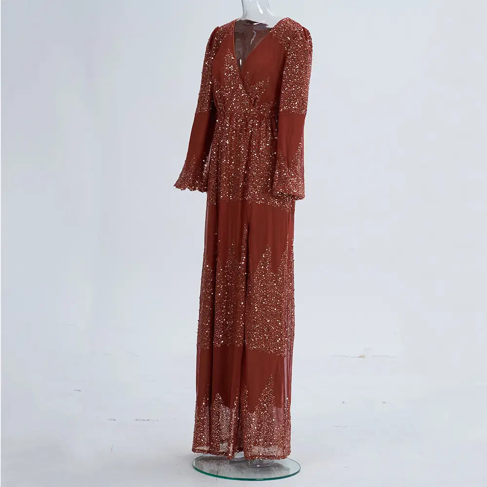 A shimmering rust-colored sexy long sequined evening dress with long flared sleeves and a v-neckline adorned with sparkling sequins across its flowing fabric.