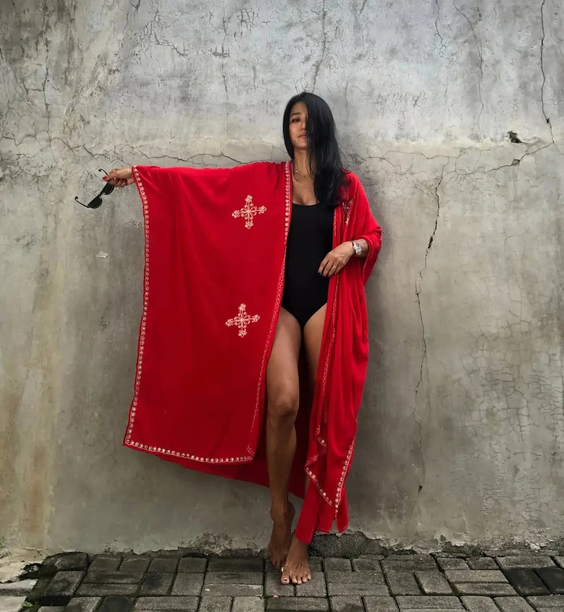 A vibrant red rayon embroidered holiday sun protection cardigan featuring long sleeves white cross motifs and decorative trim.
