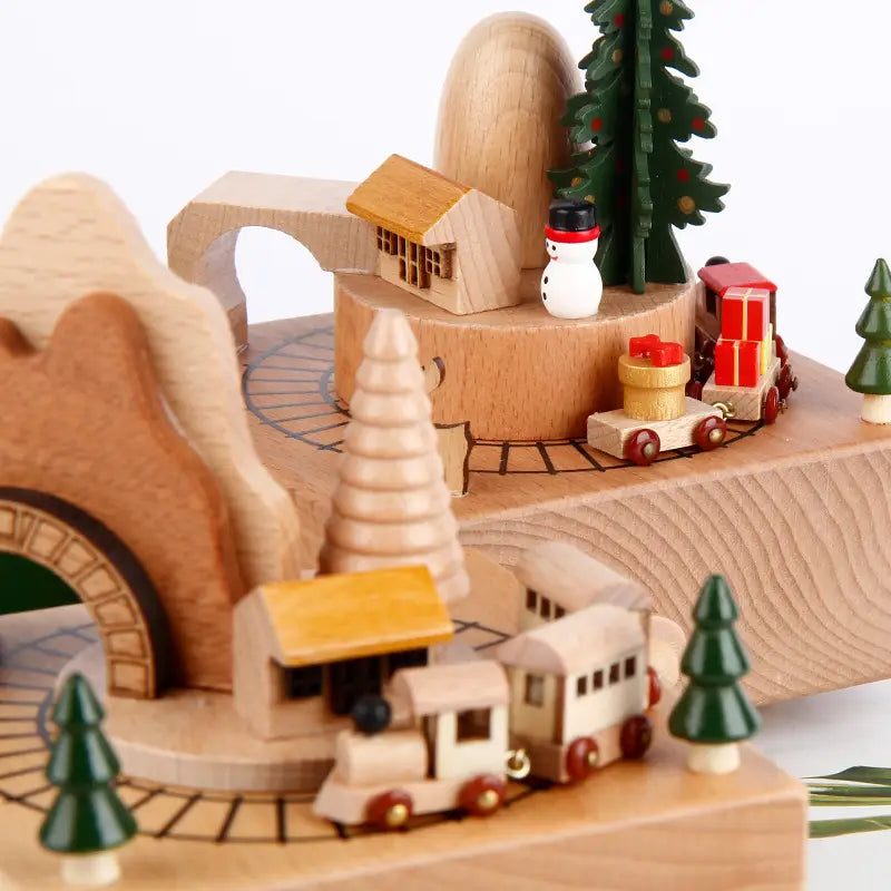 wooden christmas-themed diy dancing music box featuring a miniature train, houses, trees, and a snowman for festive decoration and entertainment.