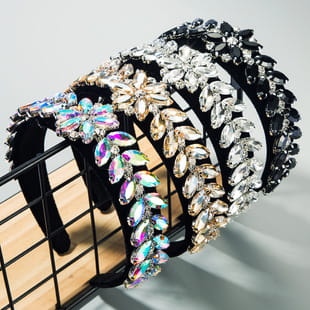 a collection of five baroque colorful headbands featuring intricate crystal and rhinestone designs in black silver gold and iridescent hues with sparkling gemstones