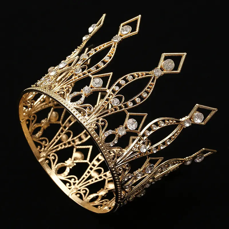 A baroque golden birthday crown cake decoration featuring a golden ornate tiara adorned with sparkling clear crystals and intricate filigree detailing.