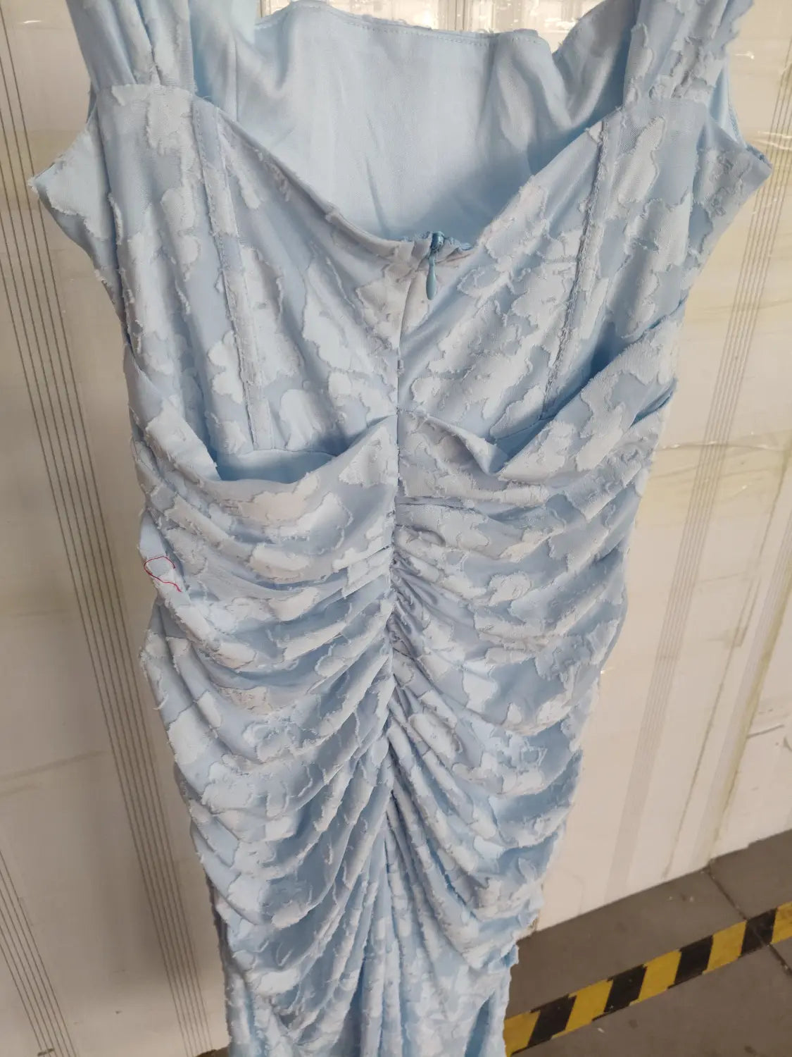a light blue ruched lace dress with a fitted bodice and flowing skirt ideal as a sexy evening dress with a backless sexy evening design