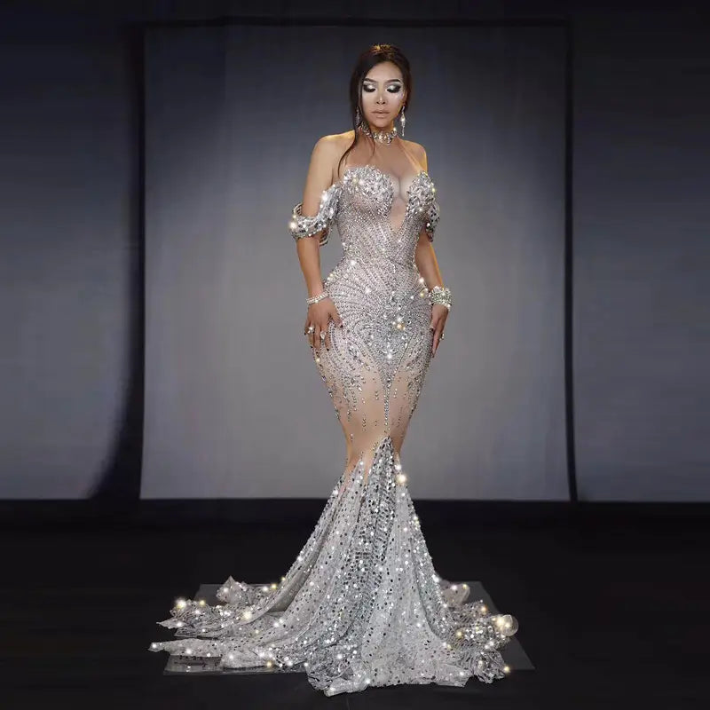 A shimmering silver mermaid gown with intricate beading and sequins, featuring off-the-shoulder sleeves and a flowing train, designed for a nightclub DJ female or female singer European stage nightclub performance.