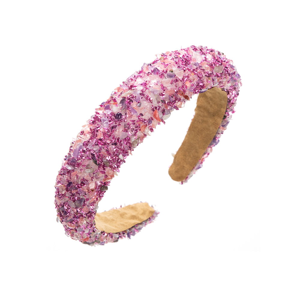 A baroque colorful headband featuring sparkling pink and purple crystal gemstones with a soft tan interior lining.