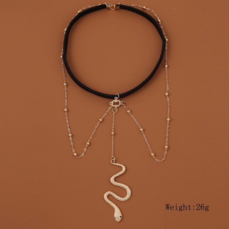 black velvet choker necklace featuring a gold-toned chain and bohemian boho gold big snake pendant in a leg chain style