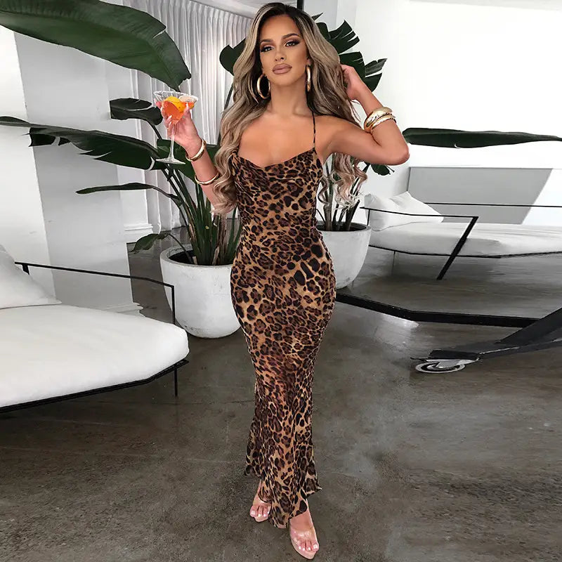 A slim fit long leopard printed lace up dress featuring a form-fitting silhouette with long sleeves and thin spaghetti straps.