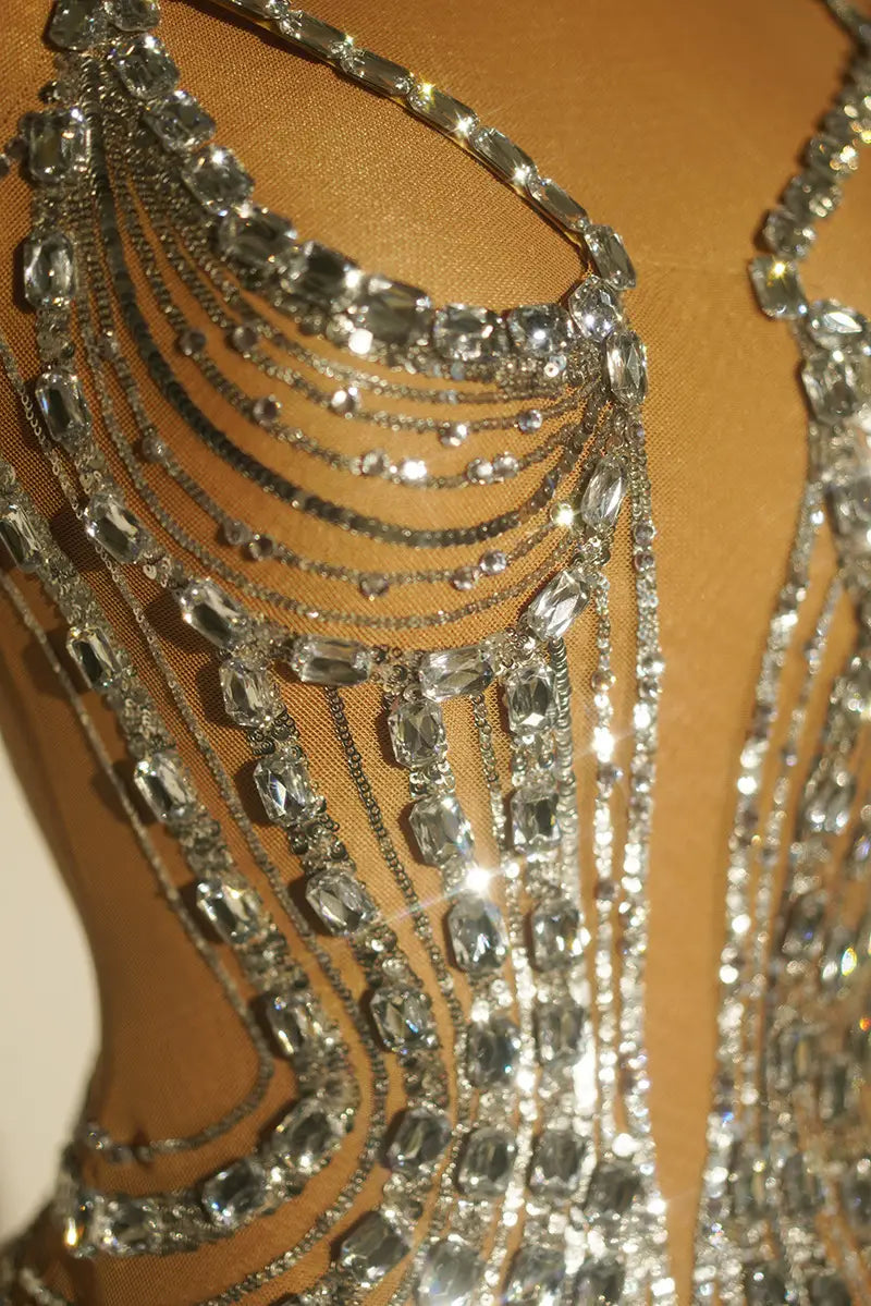 a dazzling silver rhinestone feather dress banquet gown featuring a chainmail bodysuit with cascading rows of faceted crystals and metallic links
