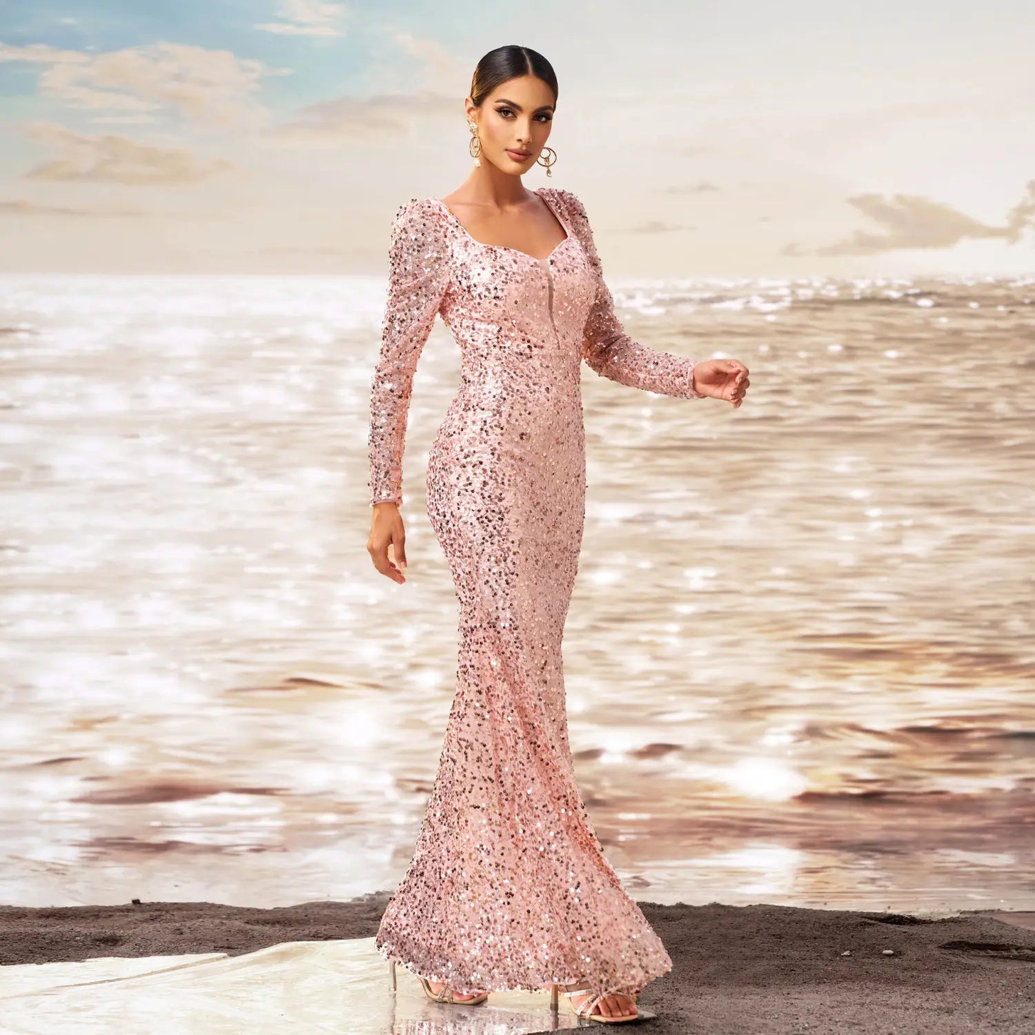 A shimmering pink long sleeve sequined sheath fishtail evening dress with a square neckline and fitted silhouette.