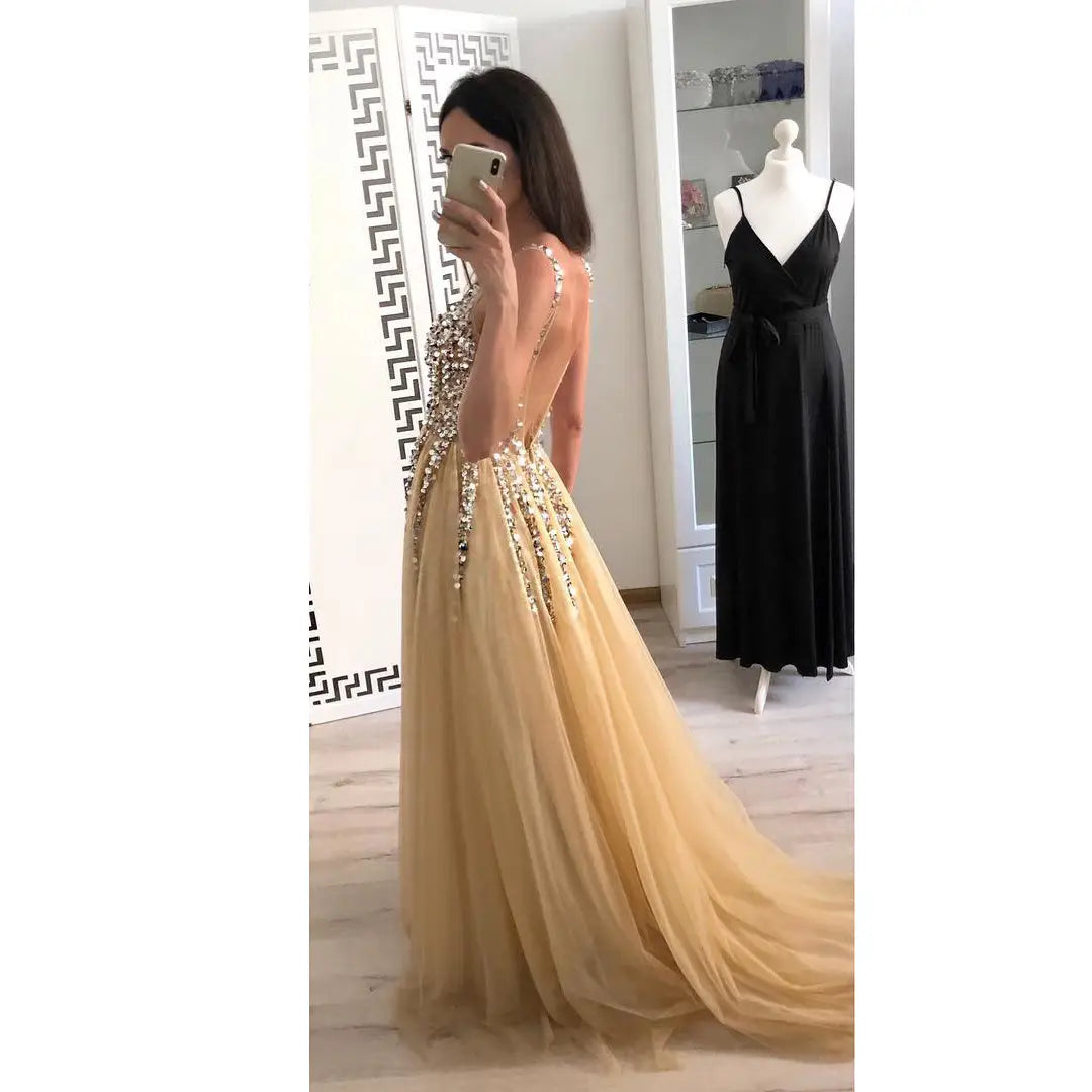 a shimmering gold tulle v-neck sequined floor-length dovetail dress with intricate beaded embellishments along the back and sides, featured as a hot sale item