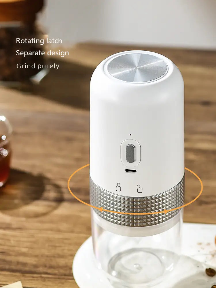portable electric ceramic coffee grinder in white and silver featuring a textured metallic band, rotating latch mechanism, and usb charging port.