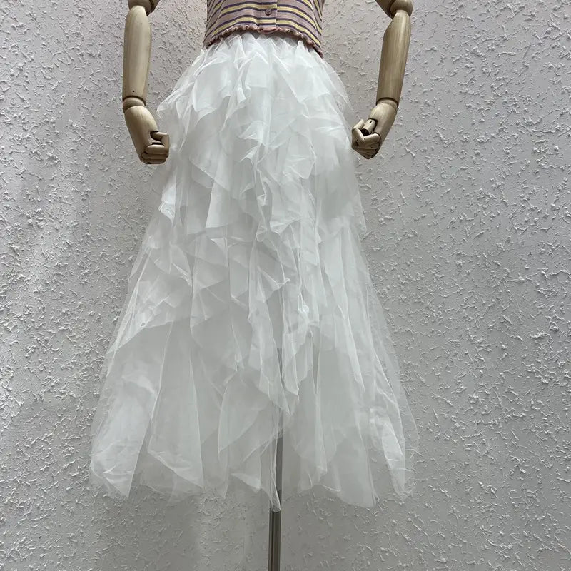 a flowing white tulle skirt with multiple ruffled layers displayed on a wooden mannequin featuring easy matching mesh stitching perfect for a mesh stitching skirt.