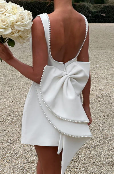 white satin backless dress summer slim featuring a large bow at the back and pearl trim along the straps and hem