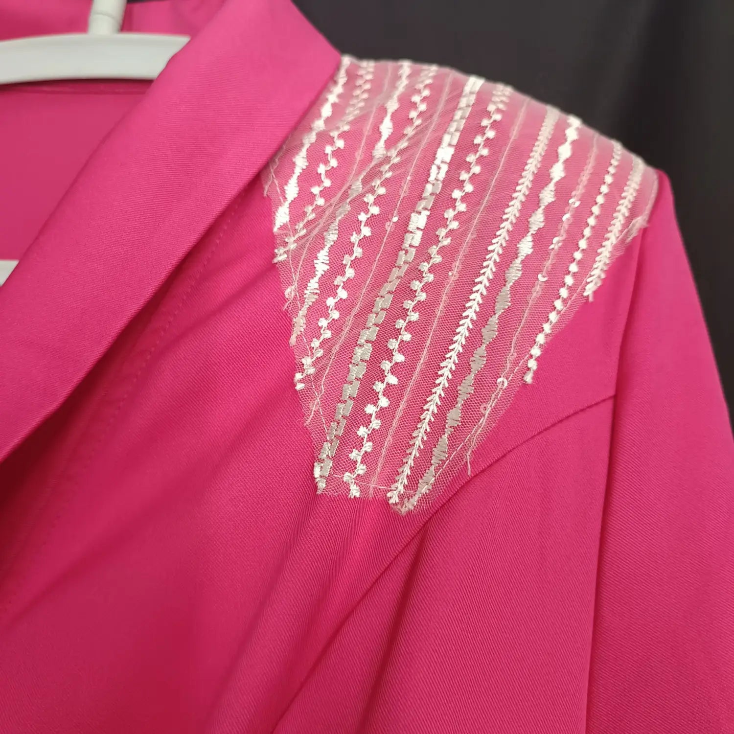A rose red suit collar wrap dress featuring a vibrant pink blazer with a sheer lace panel and silver thread embroidery along the shoulder.