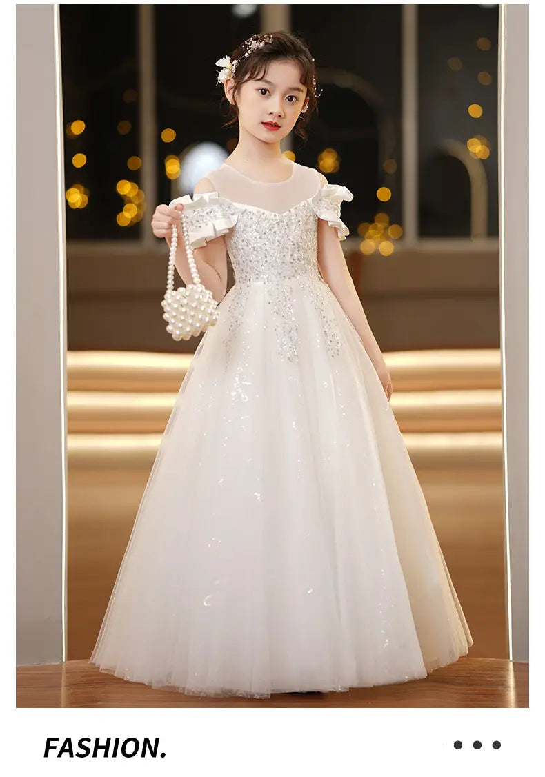 white off-the-shoulder spandex princess dress featuring a sequined bodice and sheer overlay paired with a matching pearl-handled clutch is a girls tulle tutu ideal for formal occasions.