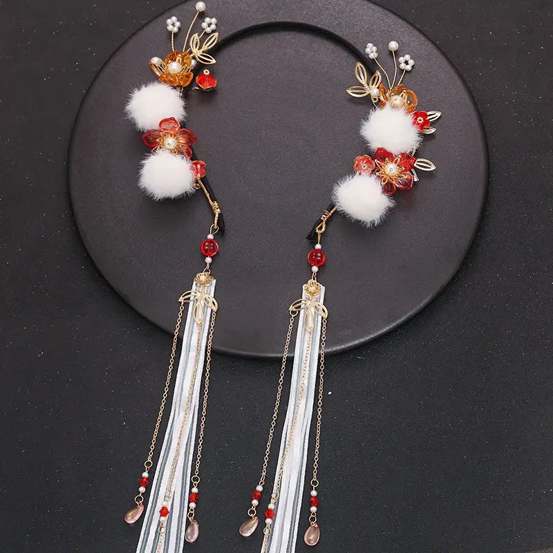 Elegant gold-toned floral hanfu tassels girls fashion headbands featuring red and orange flower designs with white faux fur pom-poms and silver ribbons and chains adorned with beads.