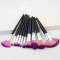 Set of ten professional makeup brushes with black handles, silver ferrules, and purple gradient makeup bristles