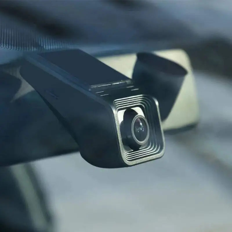 Black rectangular 1080p hd night vision driving recorder with silver-rimmed lens and sleek angular design mounted on windshield