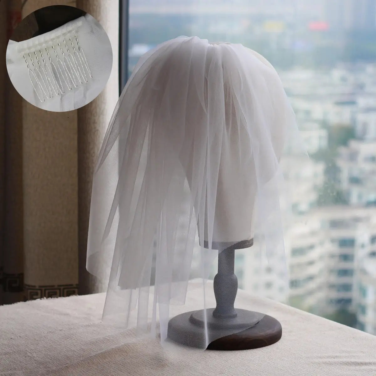 a delicate white tulle retro short wedding veil with floral lace detail and matching comb displayed on a mannequin head as a short wedding bride headdress