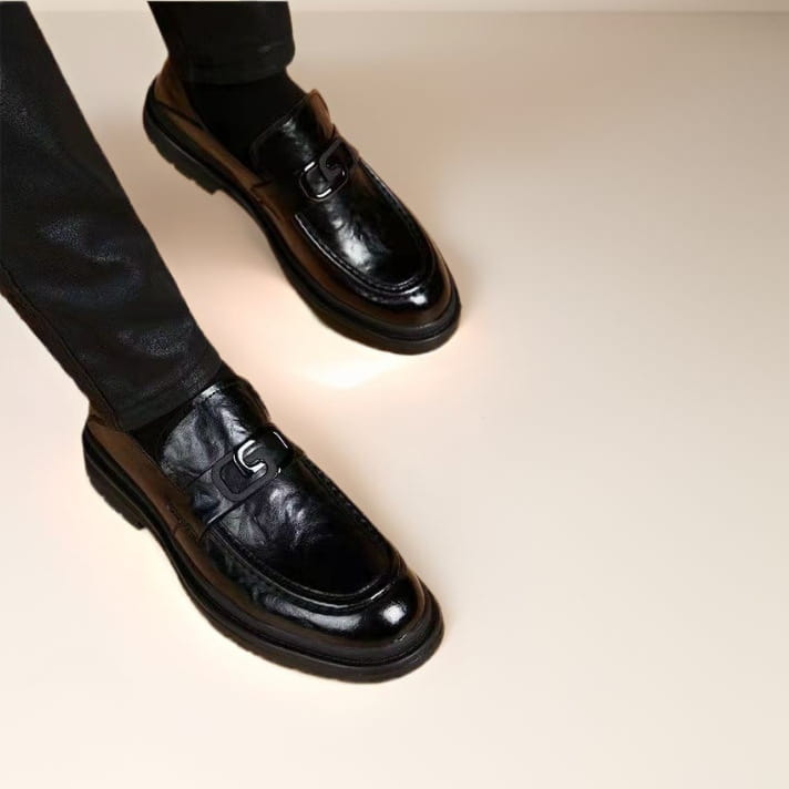 Black glossy business casual leather loafers with a glossy finish and a distinctive metallic buckle ideal for business casual wear.