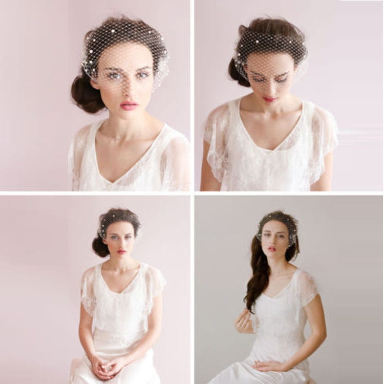 A delicate black mesh bridal veil pearl large with small pearl-like embellishments secured by a hair comb and worn elegantly over a styled updo.