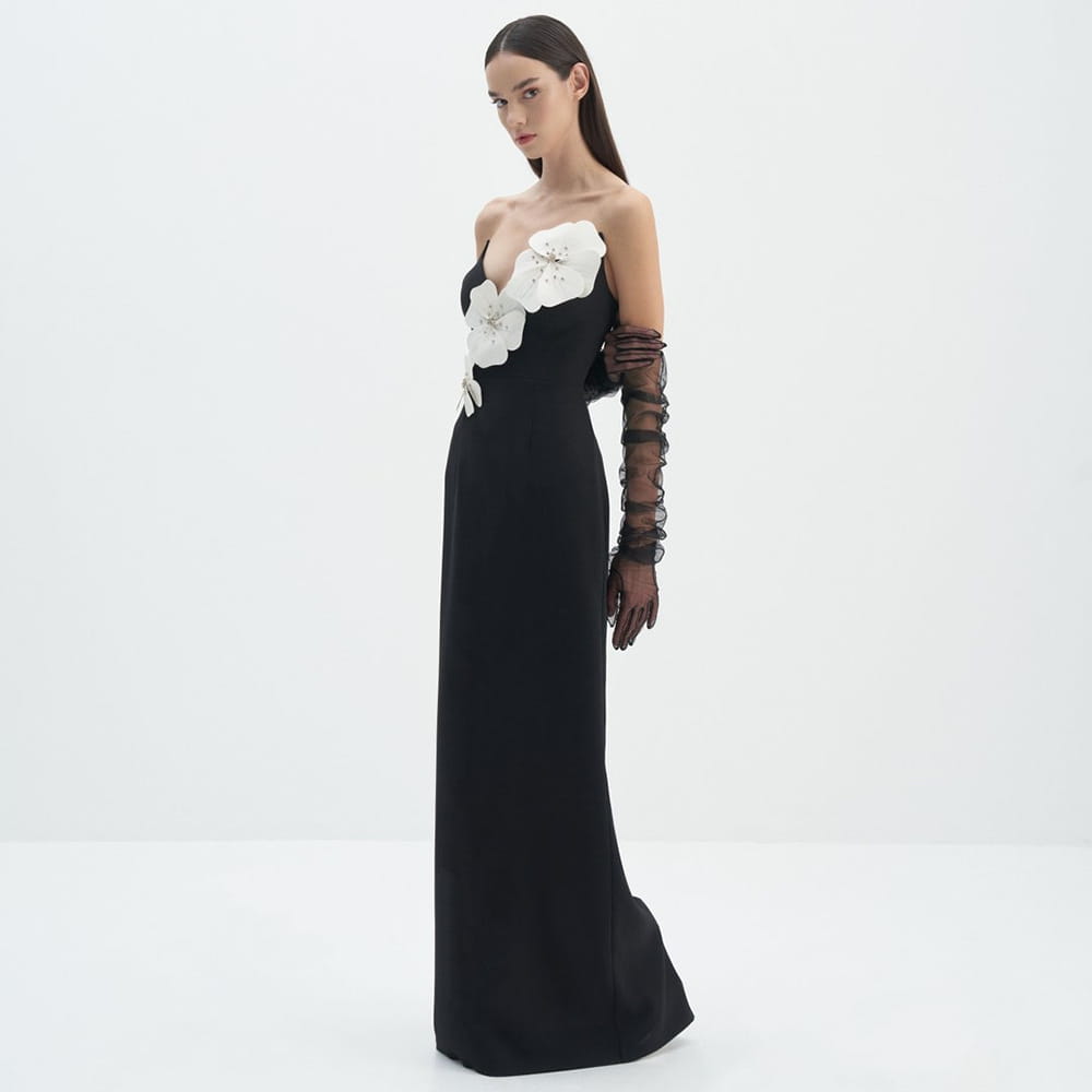 black backless bandage gown featuring a strapless design with a bandage chest white floral appliqués and paired with sheer black lace gloves