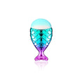 A translucent mermaid-scale perfume bottle with teal to purple gradient and light blue cap in 11pcs makeup brushes kit featuring palette