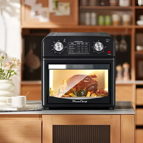 Black plumchef 12 liter air fryer oven with dual knob control and glass door roasting turkey and vegetables inside