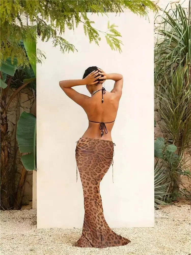 a backless, form-fitting leopard-print mermaid-style dress with thin black ties at the waist and neckline paired with a bikini strappy skirt casual suit.