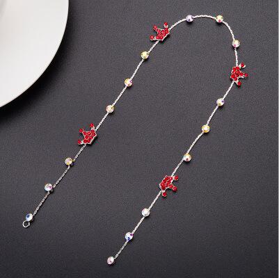A delicate silver chain wedding hair accessory adorned with red enamel roses and scattered pearls for elegant wedding hair styling.