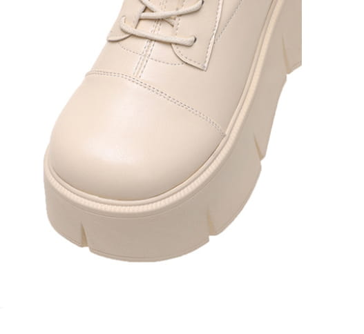 Fashion white platform lace up high boots with a cream-colored smooth leather upper and chunky textured sole.