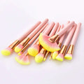 A set of 12pcs beauty makeup brushes with pink handles, gold ferrules, and soft bristles in yellow to pink gradient