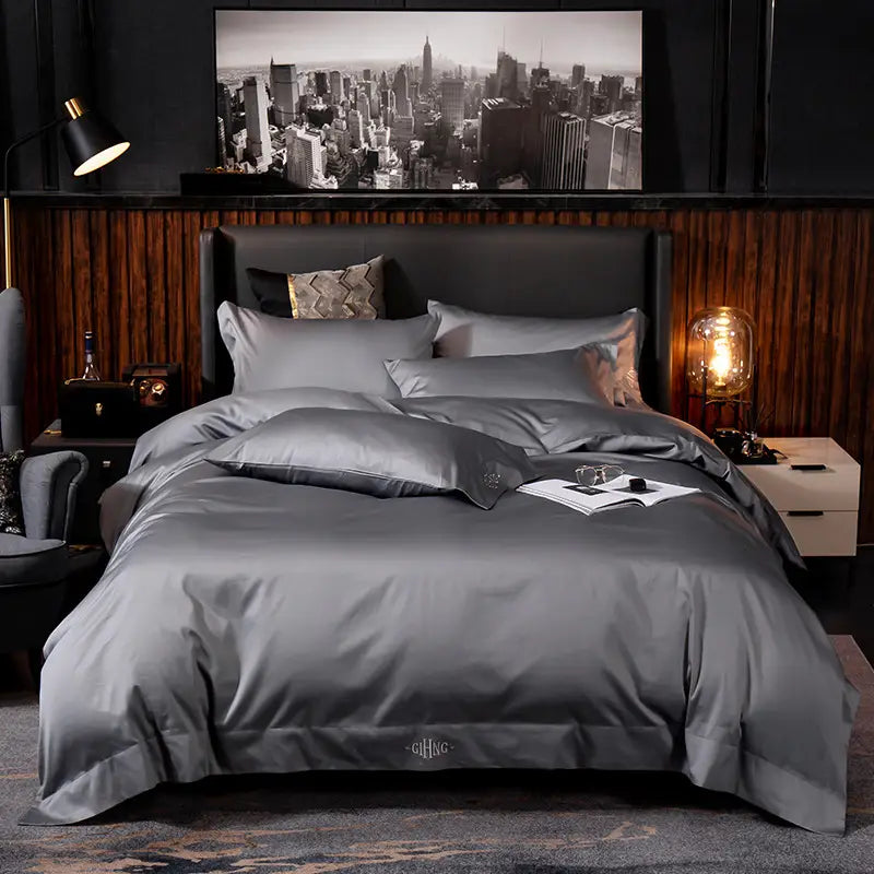 Gray satin-like four-piece bed sheet set with a subtle sheen and embroidered gifhong logo on the duvet cover designed for elegant bedroom decor.