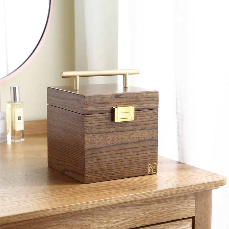A sleek dark wood classical jewelry box with a brass handle and clasp featuring a mirror and velvet interior.