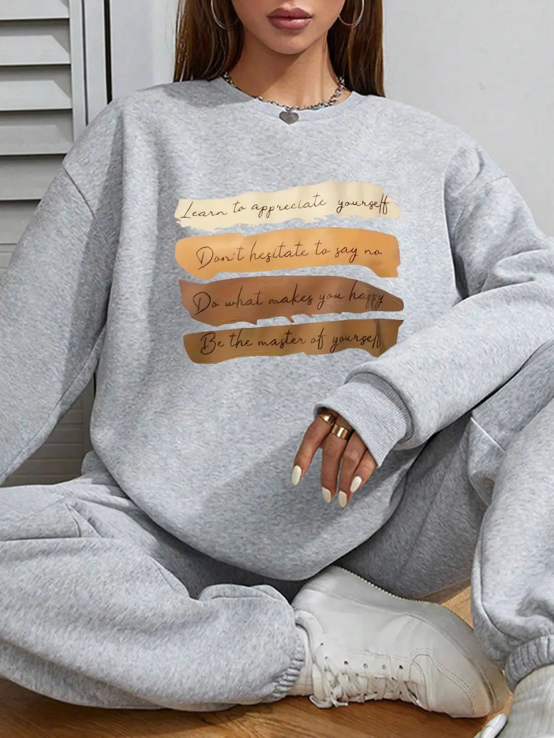 white oversized long sleeve sweatshirt in gray heathered fabric with a motivational quote printed in black and gold ideal for daily wear and solid colour styling