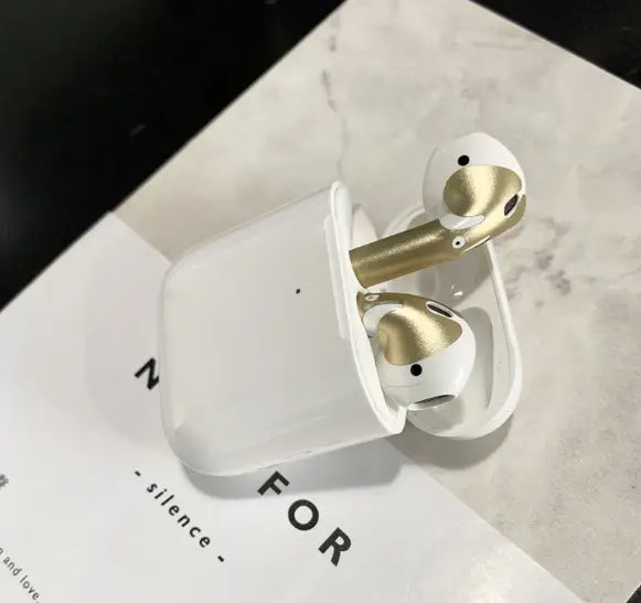White and gold apple airpods 2 with a gold glossy custom sticker skin in a matching charging case displayed from the front.