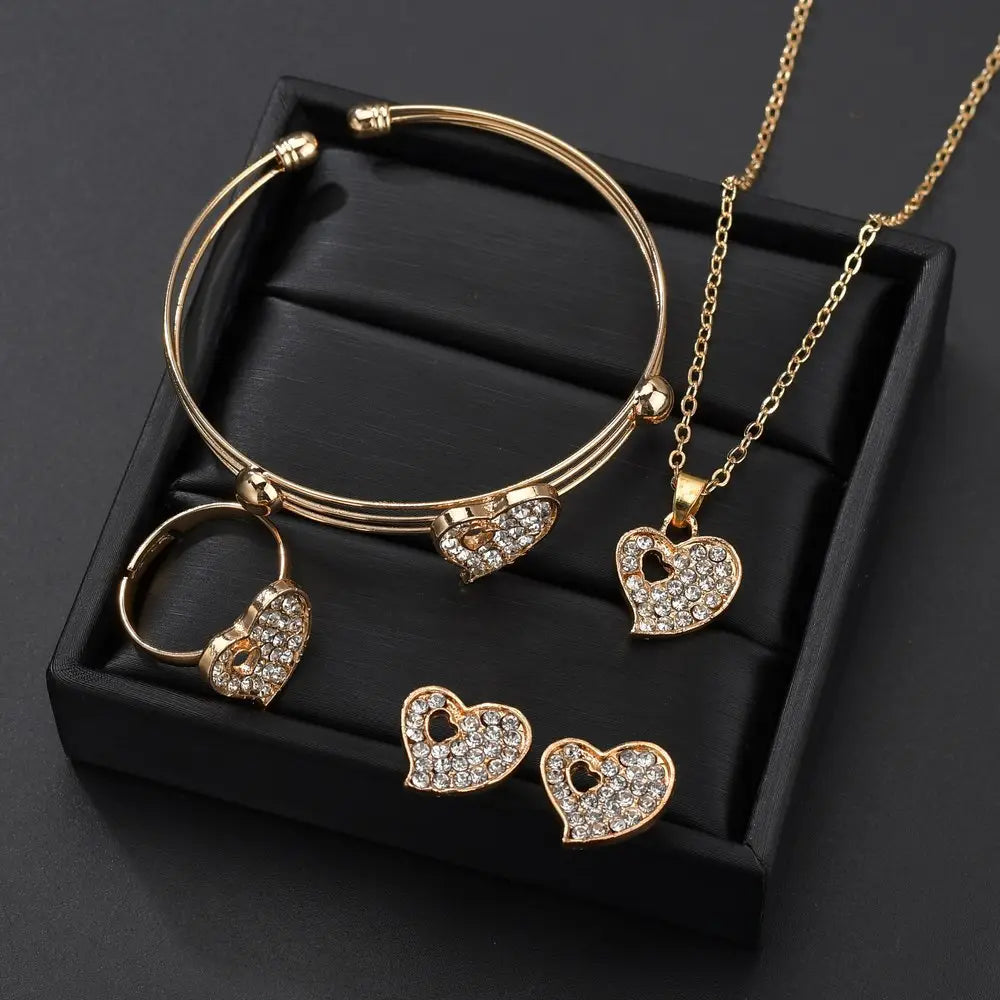 gold-toned heart-shaped love jewelry set featuring sparkling rhinestone embellishments on a delicate chain necklace and matching bangle bracelet.