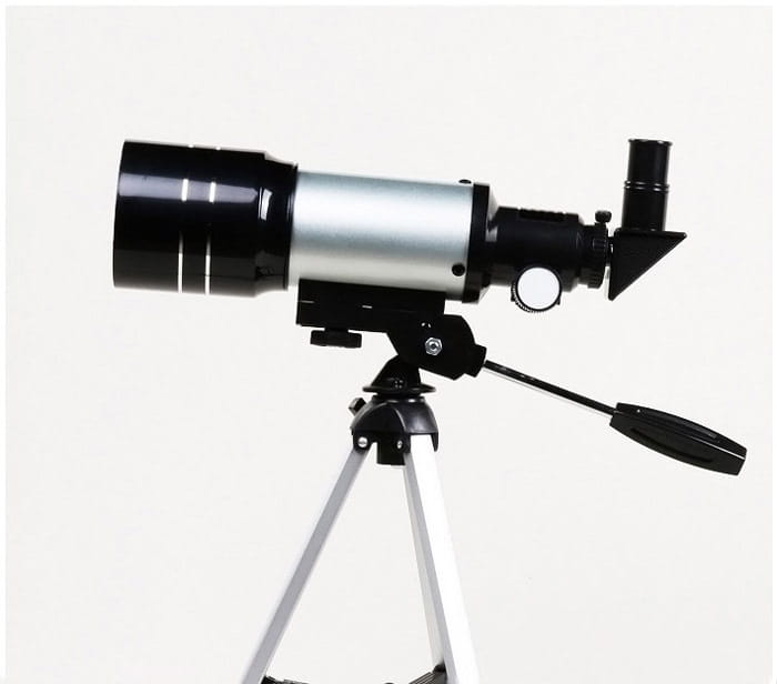 Black and silver high list tube telescope with maximum magnification mounted on a tripod featuring an eyepiece and focus knob.