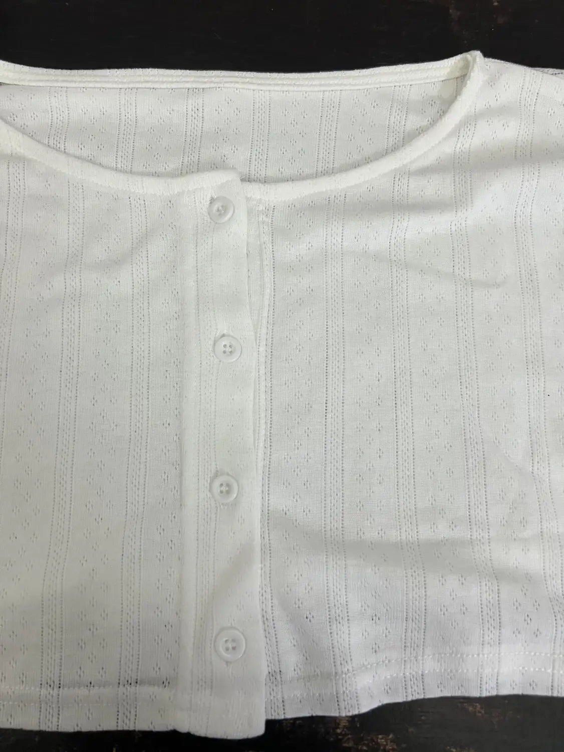 white button-up top with a subtle striped pattern and delicate eyelet detailing paired with a white ribbed knit fashion cardigan long sleeve for a stylish long sleeve look.