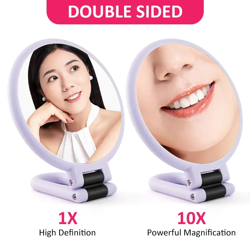 A lavender-colored mirror purple handle mirror with double-sided 10x magnification, foldable stand, and black rubberized grip sections.